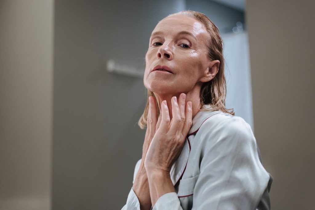 Older woman applying skincare to her face