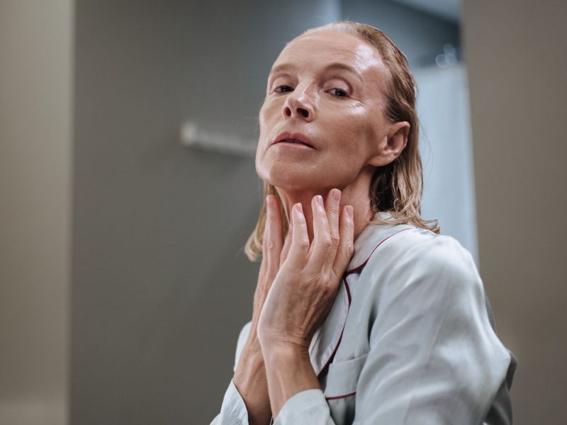 Older woman applying skincare to her face