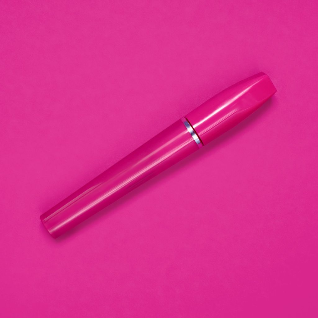 Close-up of a cosmetic product tube on a pink background