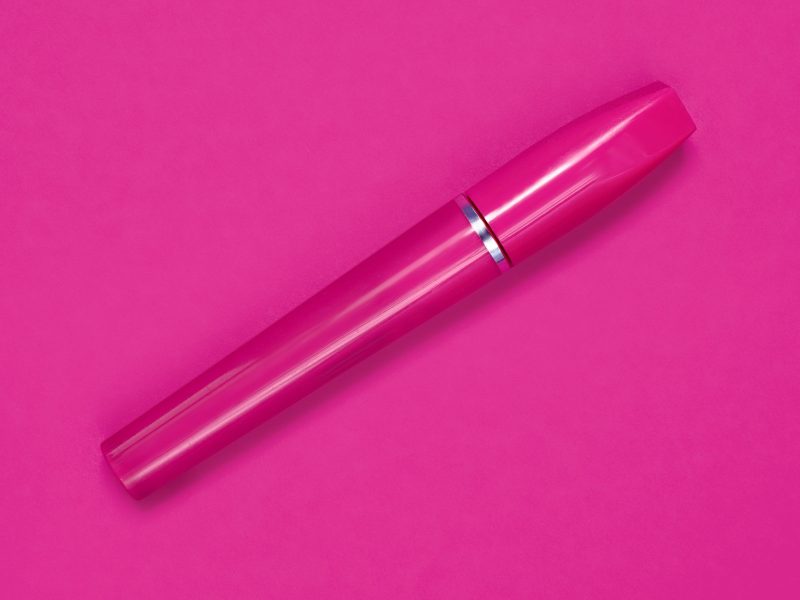 Close-up of a cosmetic product tube on a pink background