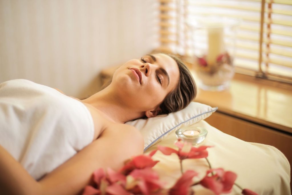 Woman relaxing at a spa in a white towel with flowers