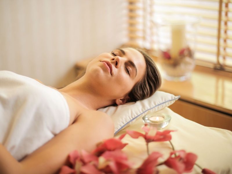 Woman relaxing at a spa in a white towel with flowers