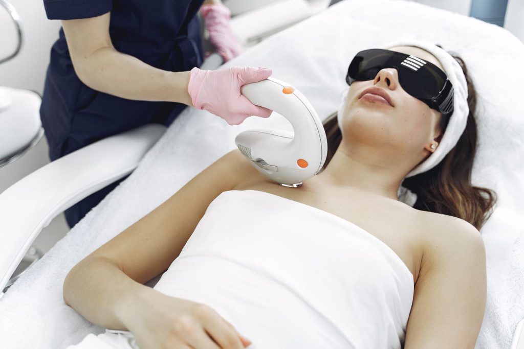 Cosmetologist performing a laser treatment on a client in a clinic