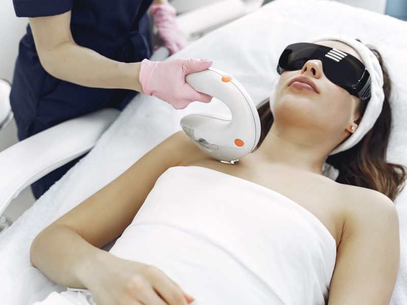 Cosmetologist performing a laser treatment on a client in a clinic